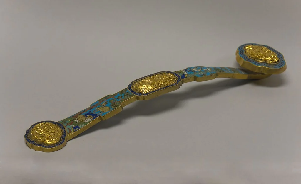 An eighteenth- to nineteenth-century cloisonné ruyi with a long curved shaft and enlarged head